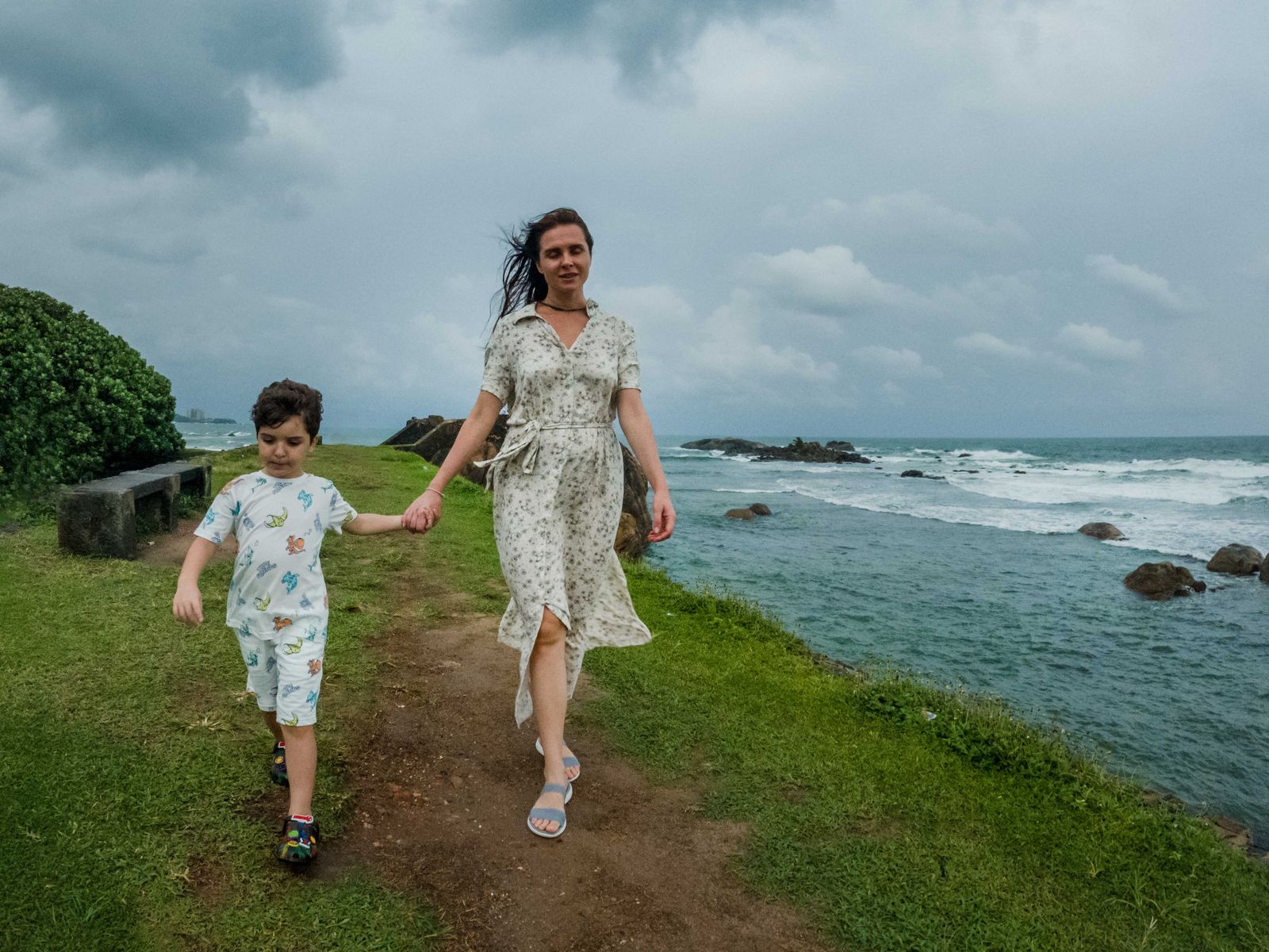 Mother and son walking along the Sri Lankan coast